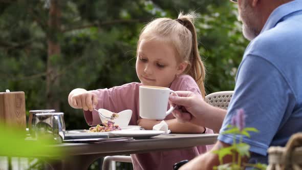 Family in Outdoor Summer Cafe