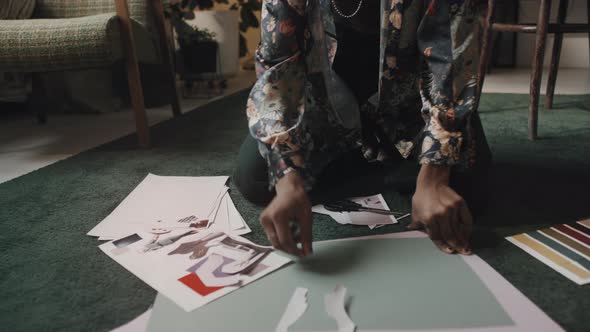 Indian Fashion Designer Working with Paper Patterns on Floor in Studio alt