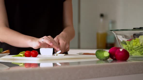 Woman Cutting Cheese in Kitchen