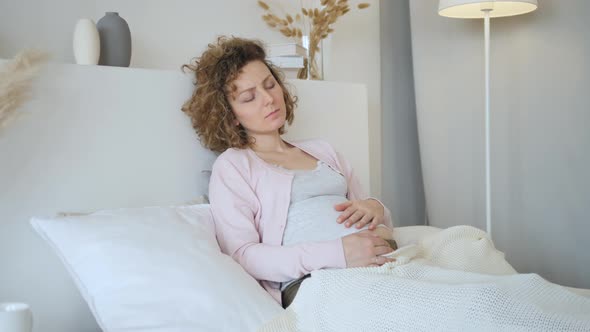 Young Upset Pregnant Woman Feeling Unwell On Bed