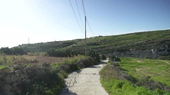 Empty Road Lading to Gozo Island Outskirts Valley on Sunny Day