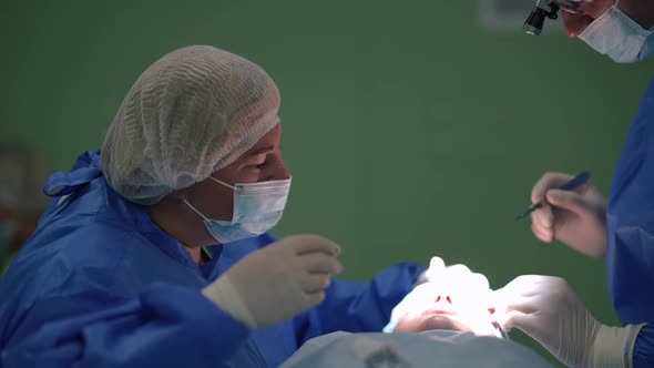 Caucasian Nurse and Surgeon Performing Operation Eyelid Surgery in Medical Clinic Indoors alt
