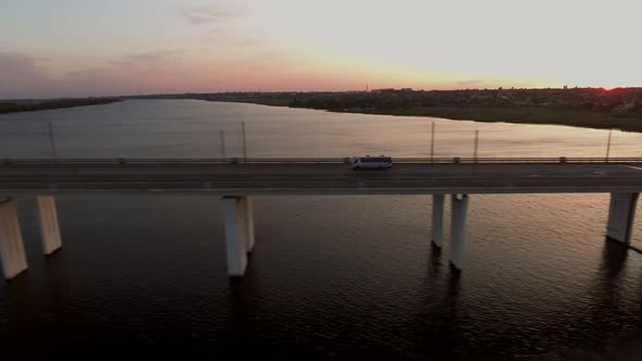 Aerial Shot of a Long Bridge with a Moving Bus in Ukraine at Sunset in Summer