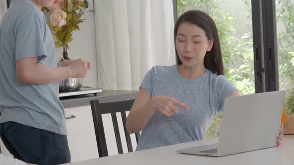 asian family making video call on laptop at home