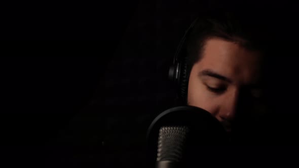 Man Sings Into Microphone Records His Song in Recording Studio Professional Singer Dark Room with