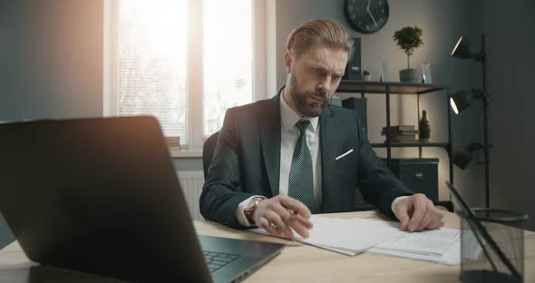 Businessman Working on Laptop in Office alt