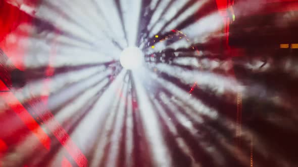 The Big Disco Ball Rotates with Many Beams of Light of White Color in a Smoke Indoors Interiors of alt