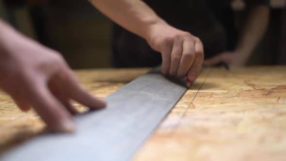 Hands Of Man Using A Ruler To Make Measurements On A Piece Of Wood. Slowmotion