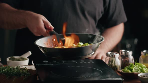 Chef Frying Green Brussels Sprouts Cabbage in Pan with Flambe Technique Closeup alt
