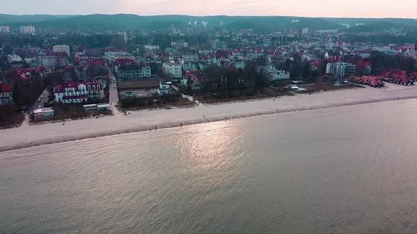 The drone is flying near the beach. Taking pictures of a coastal town.