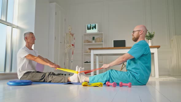 A Physical Therapist Safely Trains a Patient Using Medical Exercise Equipment alt