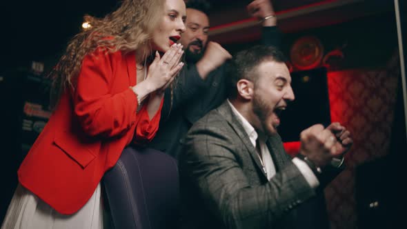 Group of Young People are Rejoice in Victory the Jackpot in a Slot Machine alt