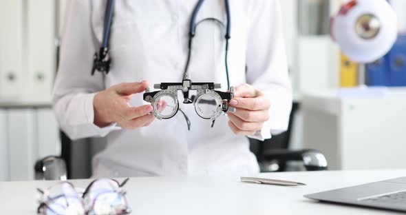 Ophthalmologist Optometrist Holds Glasses for Selection of Lenses alt