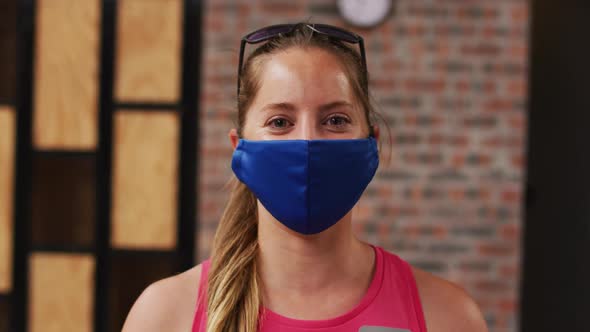 Portrait of caucasian woman wearing face mask with sunglasses on her head smiling alt