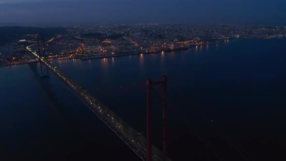 Night Aerial Panorama of Urban City Center of Lisbon in Lights with Ponte 25 De Abril Red Bridge alt