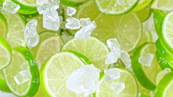 Super Slow Motion Shot of Flying Fresh Lime Slices and Crushed Ice Towards Camera at 1000Fps alt