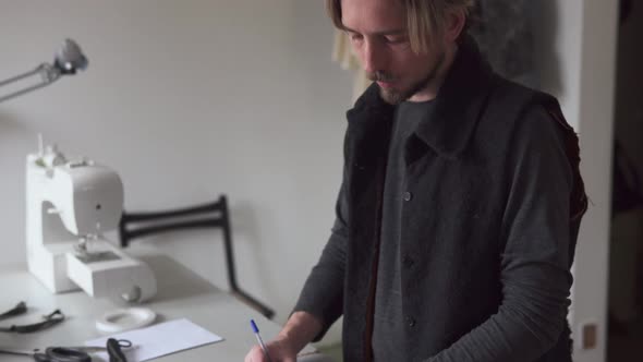 Man Fashion Designer Drawing Creative Sketch in Sewing Workshop
