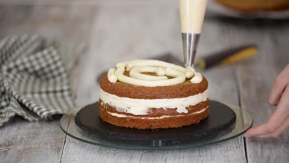 Pastry Chef's Hands Making Carrot Cake with Cream alt