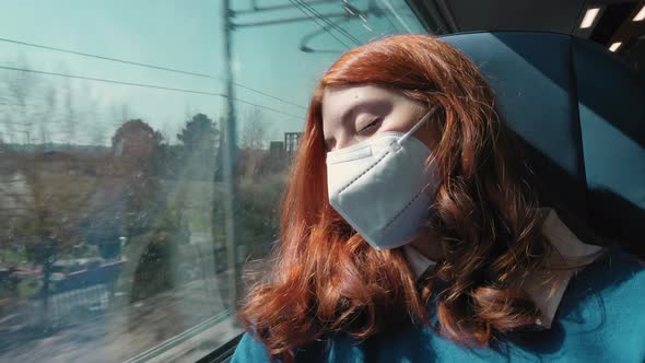 Young Girl Sleeps on the Train with Ffp2 Mask While Traveling for Work alt