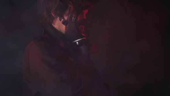 A man in a gas mask in the smoke. black background alt
