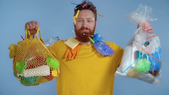 Unhappy man holding two packages with trash