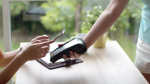 Young pretty woman payment contactless with smartphone 