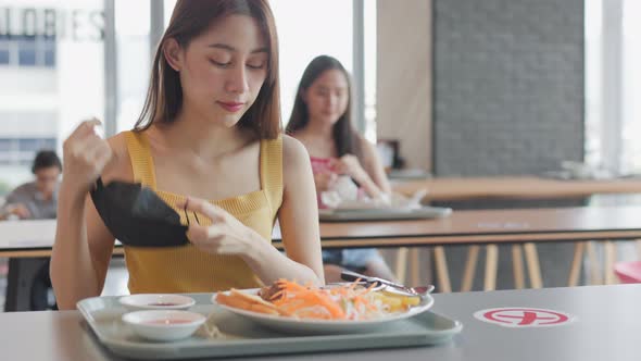 Asian woman sitting separated in restaurant eating food .keep social distance