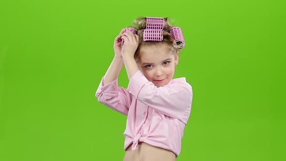 Child with Curlers on His Head, Removes Curlers. Green Screen. Slow Motion alt