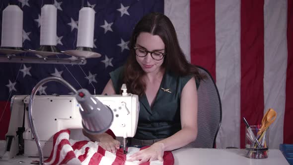 Woman using sewing machine to make American Flag alt