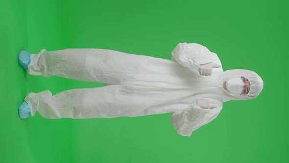 Full Body Of Asian Male Wear Protective Uniform Ppe And Showing Thumbs Up In Green Screen Studio alt