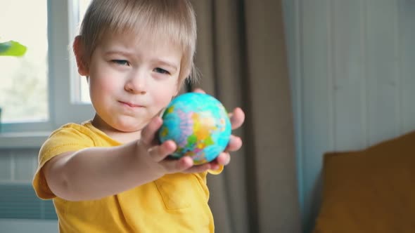 Child Boy with Blonde Hair Hugging Earth Globe Save Earth Concept alt