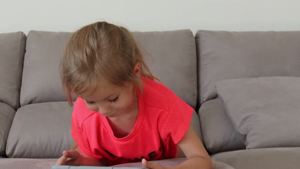 Touchscreen Girl Lying on a Gray Sofa