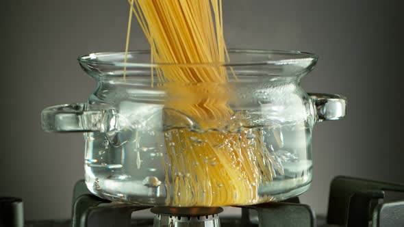 Super Slow Motion Shot of Fresh Spaghetti Falling Into Boiling Salted Water at 1000 Fps alt