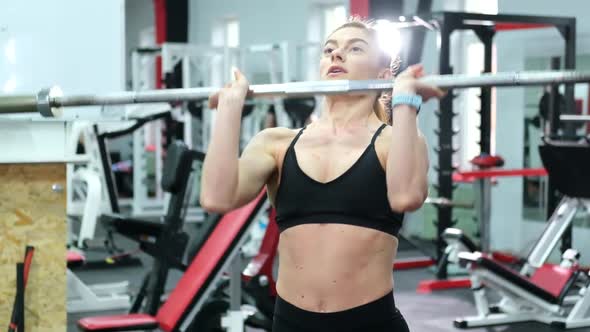 Athletic girl does a warm-up before training in the gym. alt