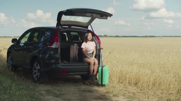 Impatient Asian Woman Waits for Friend for Car Trip alt