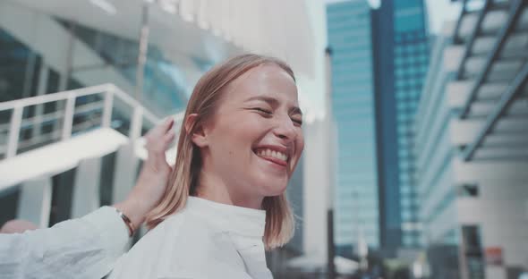 A young blond woman laughs, her hair is being fixed by others alt