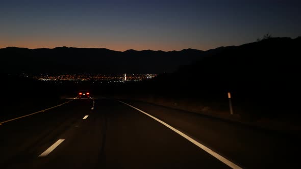 Car on Desert Valley Road at Night Highway in Twilight Dusk