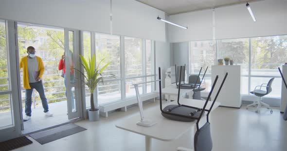 Afroamerican Workers in Safety Mask Walking in Modern Empty Office alt