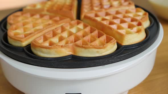 Flour Waffles on an Automatic Waffle Iron on the Table alt