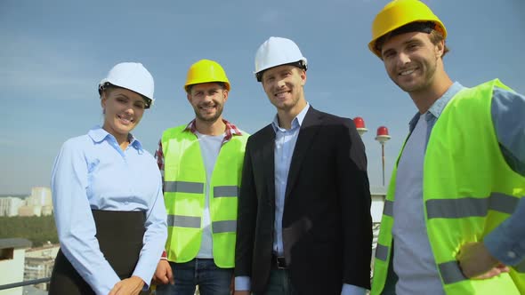 Happy Engineers and Workers in Helmets Smiling on Camera, Construction Service