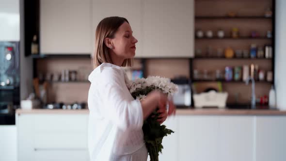 Beauty Delicate Woman Enjoys a Bouquet of White Flowers