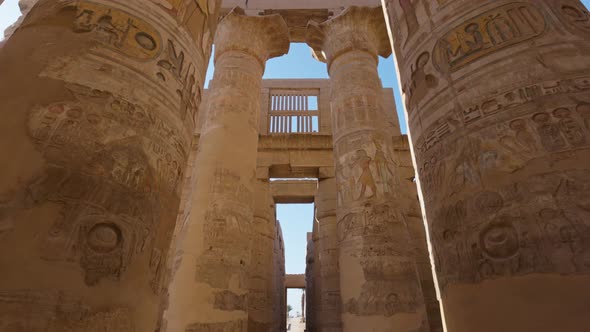 Camera Moves Between Majestic Columns with Ancient Egyptian Drawings alt