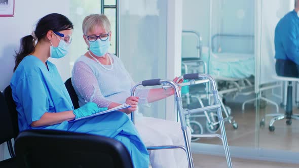 Medical Assistant Filling Documents for Senior Patient alt