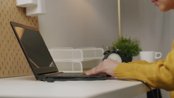 Businesswoman typing keyboard and scrolling touchpad on a laptop. alt