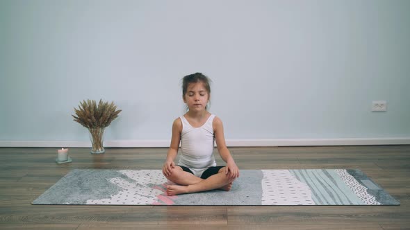 Caucasian Girl Does Yoga Baby Sits in the Lotus Position and Yawns Girl is Tired Yoga for Beginners