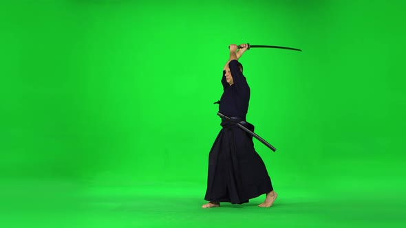 Masculine Kendo Warrior Practicing Martial Art with the Bamboo Bokken on Green Screen alt