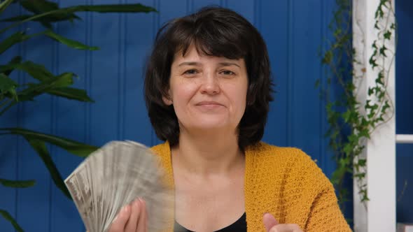 Middle Aged Woman Waving Dollar Banknotes