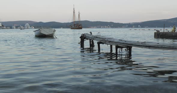 A Boat Tied To a Wooden Pier in the Sea in the Evening