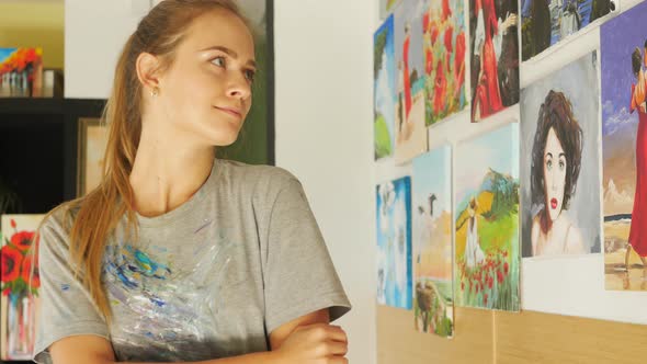 female artist admires her paintings