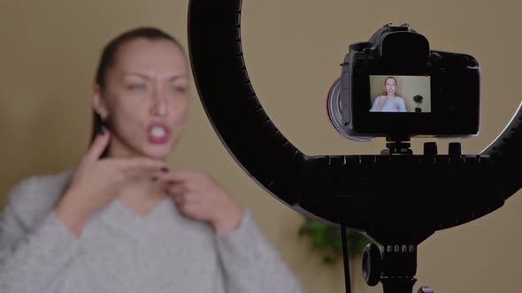 Young Female Vlogger Doing Online Face Lifting Exercises for Face Contour